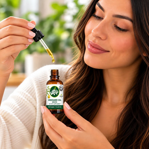 Woman using Mexican wild oregano oil drops from a 1 oz amber glass bottle
