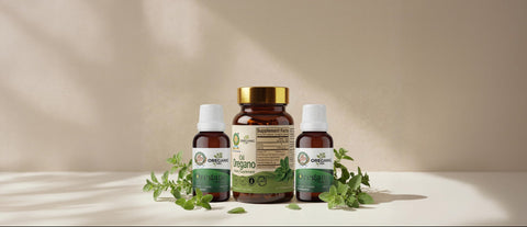 Botellas de aceite de orégano OreganicUSA en cápsulas y líquido sobre una escena natural y elegante con hojas de orégano.